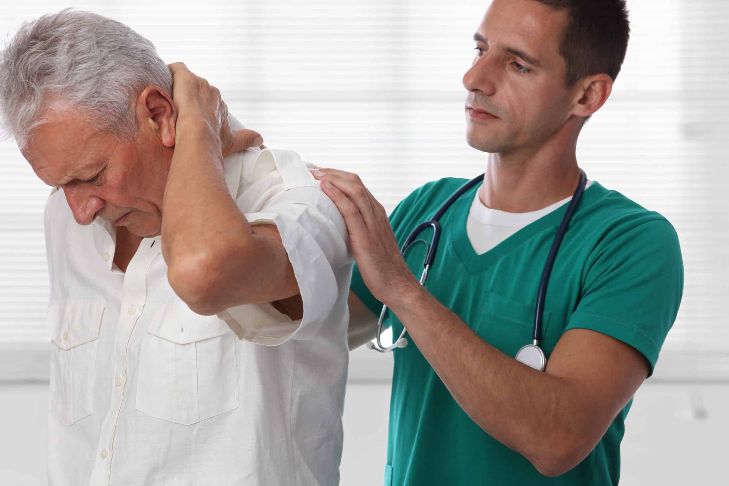 Medical professional addressing older man’s trigger points in neck area