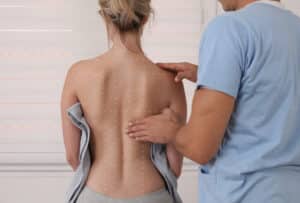 Woman having her spine examined in preparation for spinal cord stimulation treatment.