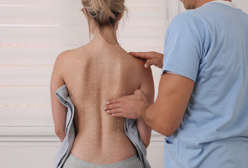 Woman having her spine examined in preparation for spinal cord stimulation treatment.