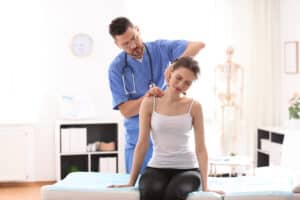 Doctor examining a woman's chronic neck pain, in need of Radiofrequncy Ablation treatment