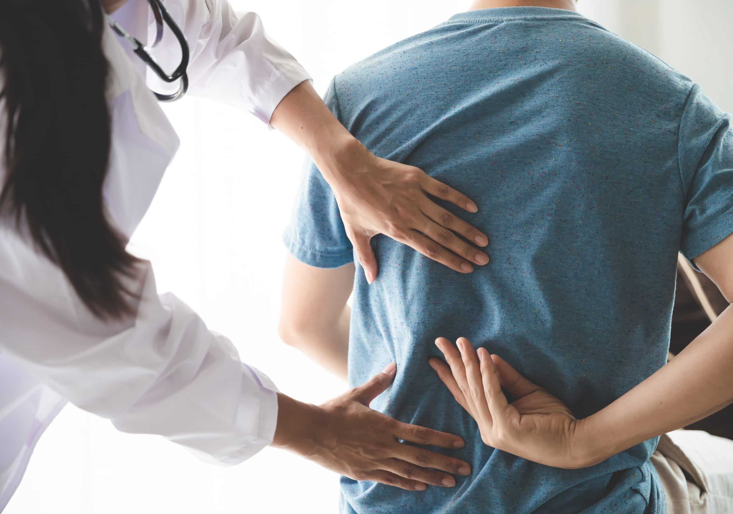 Patient having a consultation with their doctor about their back pain to discuss treatment options
