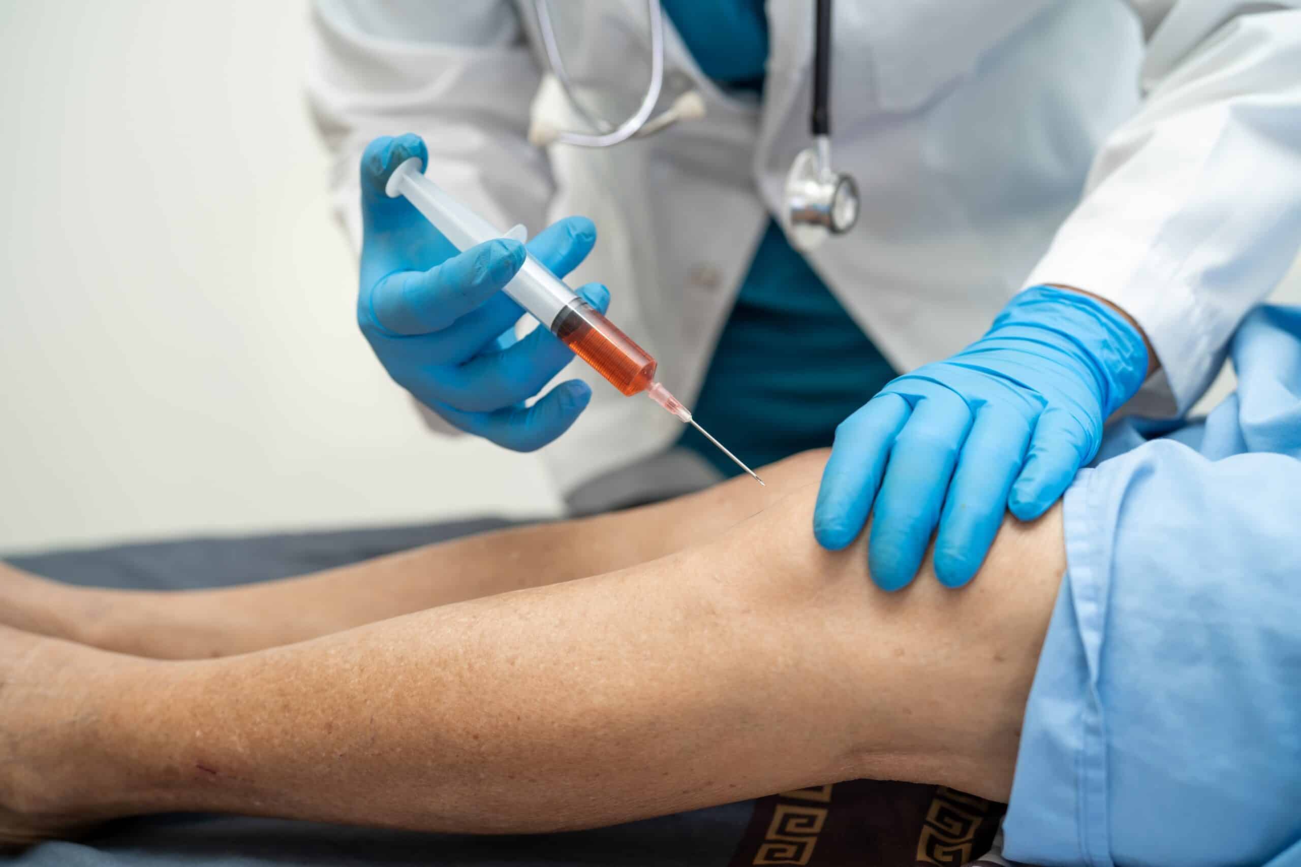 Patient receiving a PRP injection to their knee to help with chronic pain