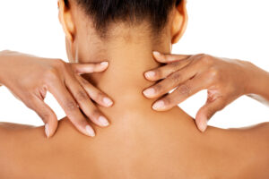 Close-up of the back of a woman's neck, a trigger point for her chronic muscle pain.