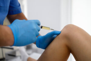 Patient receiving an intraarticular injection to their knee to help relieve joint pain.
