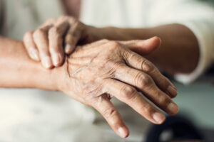 Close-up of an older person's hands, suffering from nerve or myofascial pain and in need of diagnosis.